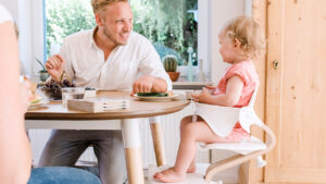 Ferienhaus Papa mit Kind am Tisch